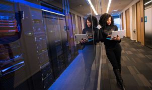 A technology professional reviewing systems beside a corporate data centre