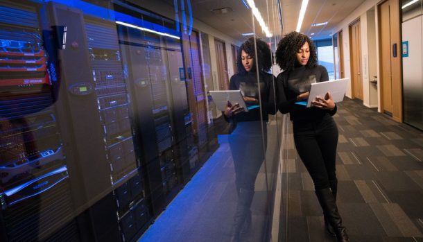 A technology professional reviewing systems beside a corporate data centre