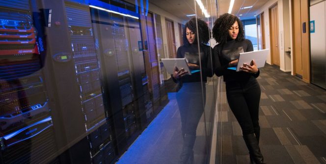A technology professional reviewing systems beside a corporate data centre